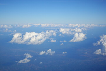 Fototapeta premium White clouds drift across the stratosphere against a blue sky. A few clouds dot the otherwise brilliant and pure sky. As if gazing up at a picturesque day, the scene is calm and tranquil.