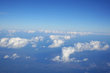 White clouds drift across the stratosphere against a blue sky. A few clouds dot the otherwise brilliant and pure sky. As if gazing up at a picturesque day, the scene is calm and tranquil.