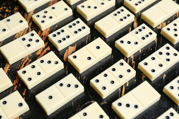 Texture of white dominos blocks on black wooden background