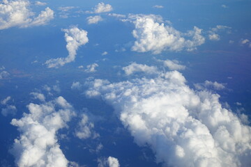 White clouds drift across the stratosphere against a blue sky. A few clouds dot the otherwise brilliant and pure sky. As if gazing up at a picturesque day, the scene is calm and tranquil.