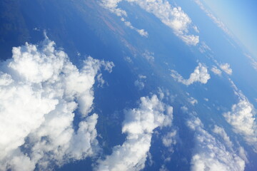 White clouds drift across the stratosphere against a blue sky. A few clouds dot the otherwise brilliant and pure sky. As if gazing up at a picturesque day, the scene is calm and tranquil.