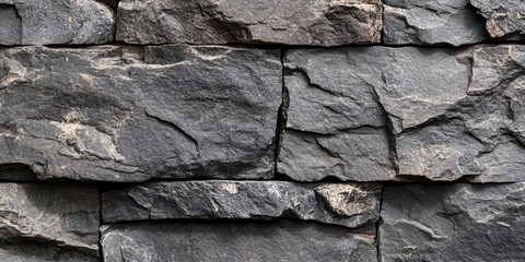 Fototapeta premium Textured background featuring a gray stone wall, showcasing the natural patterns and surfaces of the gray stone wall that creates an interesting visual appeal for various design projects.