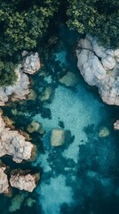Aerial view of clear turquoise waters surrounded by rocky formations and lush greenery.