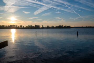 Beautiful blue sky reflected in the water of the lake during sunset.