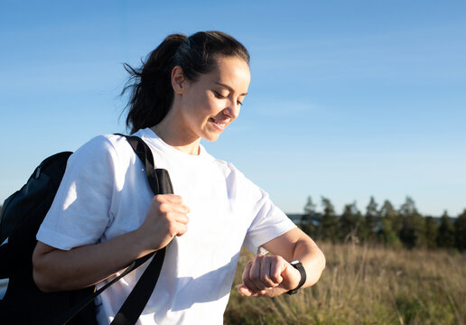 woman checking her sports watch ready to play sports outdoors