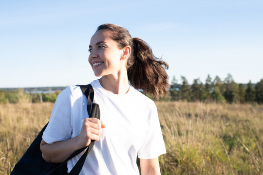 woman smiling after exercising outdoors in the sun