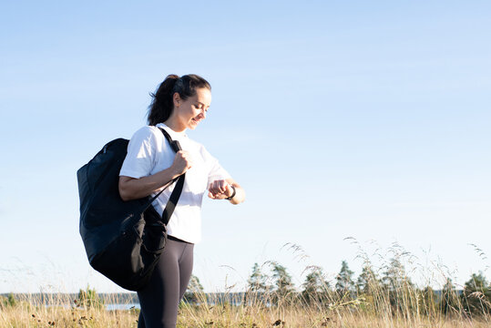 woman looking at her sports watch ready to exercise outside