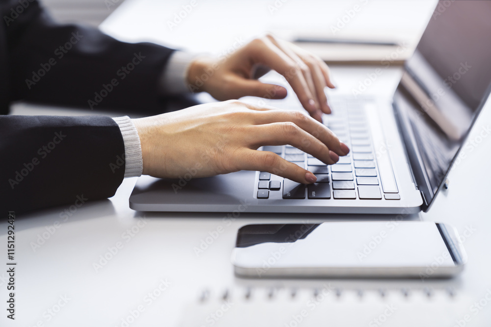 Poster with a blurred office environment in the backdrop, the image focuses on a woman's hands typing on a 