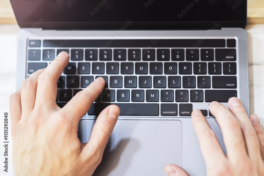 Poster a close-up reveals a man's hands swiftly typing on the keyboard of a modern laptop, with a blurred o