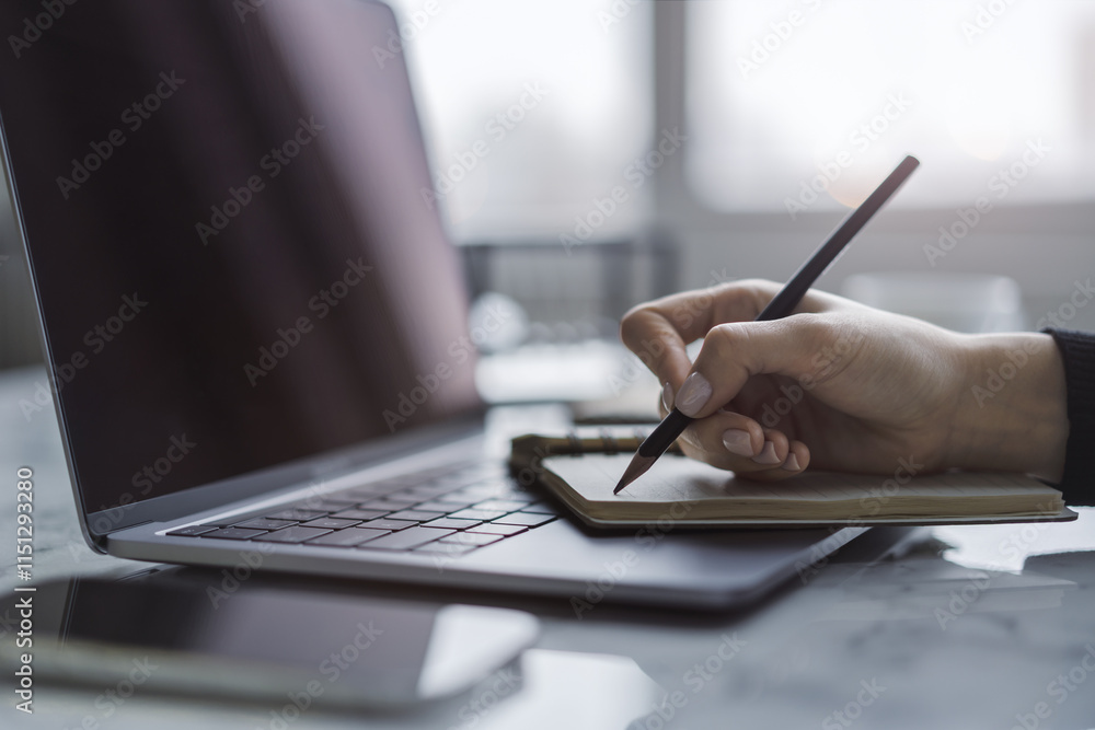 Poster closeup illustration of a woman's hand engaged in writing in a notepad on a stylish laptop, with a s