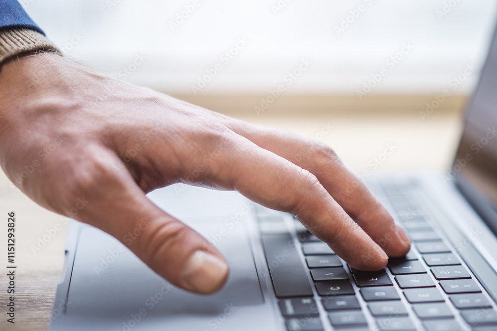 Poster set against a blurred office scene, the image reveals a close-up of a man's hands typing on a modern