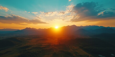 Aerial view showcasing a stunning sunset with mountains in the background, emphasizing the breathtaking beauty of nature in this scenic landscape. The aerial view captures the essence of tranquility.