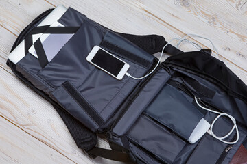 FlatLays Ideas. Flat Lay Top View of Backpack With Laptop and Tablet, Mobile Phone And Charger Inside Over White