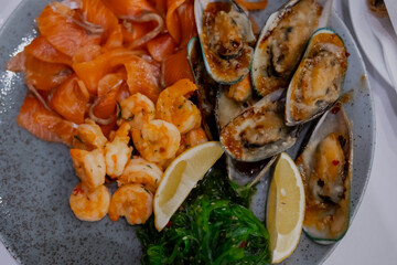 Tasty sea food dish of  shrimps, salmon and oysters. Top view of delicious dish