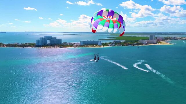 drone shot flying very close to a parachute on a sunny day with beautiful transparent and vivid blue water in cancun quintana roo