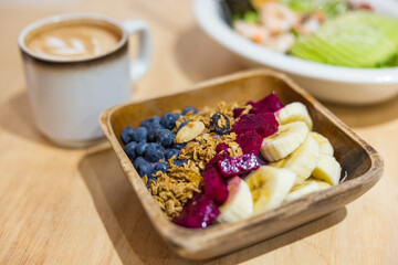 Healthy breakfast bowl with fresh fruits and coffee