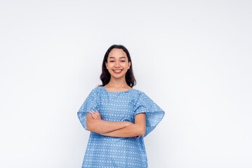 Portrait of a cheerful woman with folded arms wearing a patterned blue patient gown against a white background.
