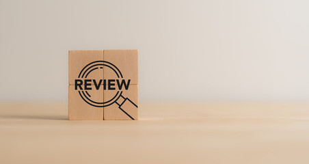Business review concept. Wooden blocks with review text and magnifying glass icon. Business and...