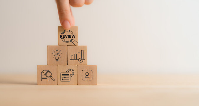Business review concept. Wooden blocks with review text and review icons. Business and customer review for business strategic planning. End of the year business. Learn, improve and develop.