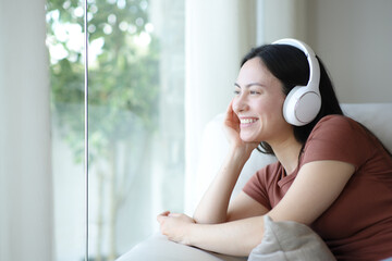 Happy asian woman wearing headphone listening audio relaxing