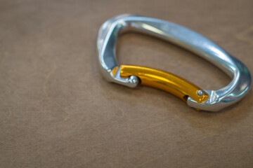 Climbing carabiner on a gray background close-up, selective focus