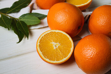 Fresh oranges on a light table. Half an orange next to whole ones