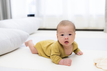 Baby exploring and lying on soft play mat at home