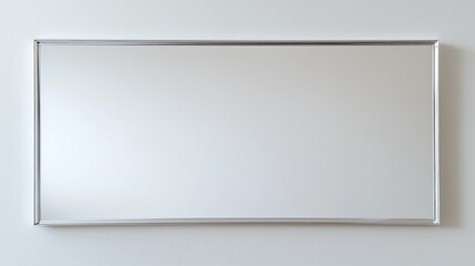 A sleek rectangular mirror with a minimalist silver frame against a light wall.