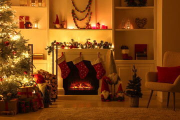 Stylish fireplace, Christmas tree with festive decor and presents indoors