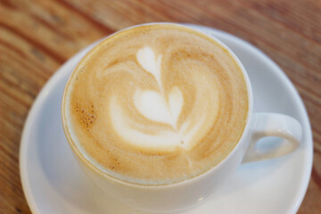 Cappuccino coffee in a white mug on a table in a cafe