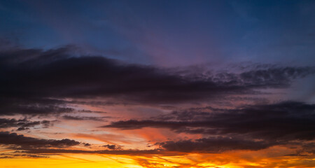 Sunrise sky background. Dramatic scenery sunset. Sky with clouds in Sunrise sky light background. Sunrise with clouds in various shapes. Calm Sunrise sky and sun through clouds over.