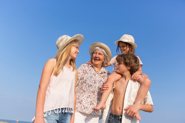 Happy grandmother with grandchildren under blue sky