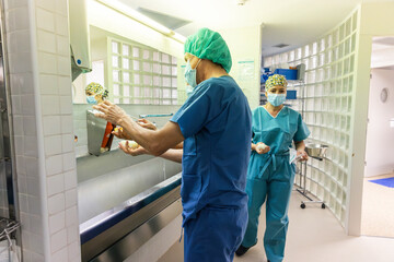 Surgeons washing hands with soap in bathroom sink