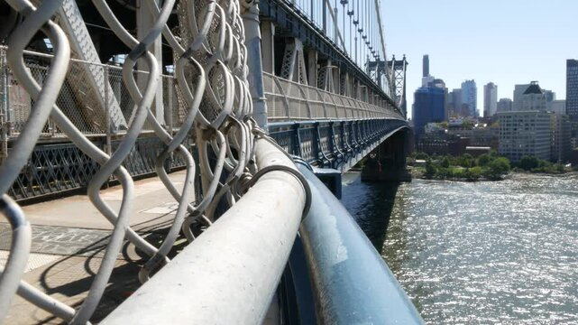 New York City Manhattan Bridge to Dumbo, Brooklyn. Waterfront skyline cityscape from pedestrian path. East river water. Riverfront architecture. Ferry boat.
