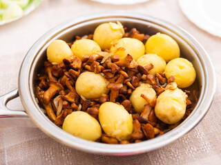 Delicious fried chanterelles with new potatoes in a frying pan