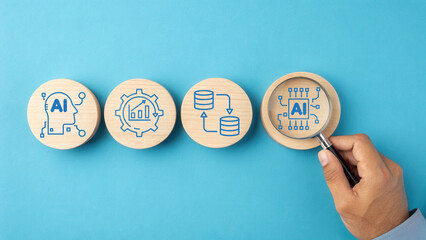 A hand examines wooden tokens featuring AI-related icons on a blue background, illustrating concepts of artificial intelligence and data management.