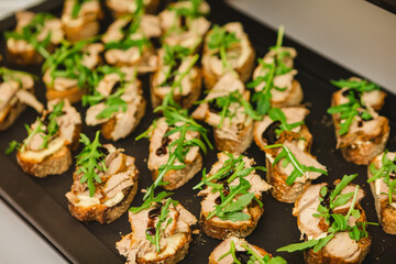 Gourmet bruschetta appetizers featuring slices of bread topped with meat, arugula