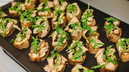 Gourmet bruschetta appetizers featuring slices of bread topped with meat, arugula