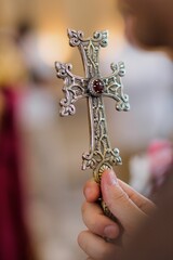 Ornate silver cross in hand during ceremony.