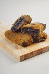 vegetables risoles enclosed in crepe-like wrappers and rolled into bread crumbs and fried. served on wood plate. perfect for recipe, article, catalogue, promotion, or any cooking contents.