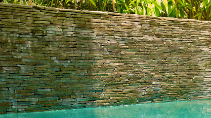 Stone wall with water. Wall made of small stones. Texture stone wall. Background stone wall.