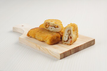 vegetables risoles enclosed in crepe-like wrappers and rolled into bread crumbs and fried. served on wood plate. perfect for recipe, article, catalogue, promotion, or any cooking contents.