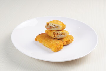 vegetables risoles enclosed in crepe-like wrappers and rolled into bread crumbs and fried. served on wood plate. perfect for recipe, article, catalogue, promotion, or any cooking contents.