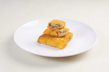 vegetables risoles enclosed in crepe-like wrappers and rolled into bread crumbs and fried. served on wood plate. perfect for recipe, article, catalogue, promotion, or any cooking contents.
