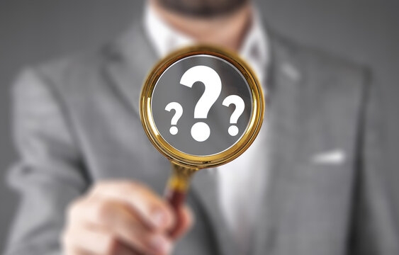 Question mark, Problem solving and analysis concept. Businessman holds magnifying glass focused on question mark, analysis, problem solving, identifying cause of issues during work process, solution,