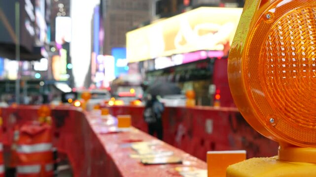 New York City Times Square, Manhattan Midtown Broadway street, USA. Defocused american NYC urban road traffic, people. Advertising signs, commercial billboard screens. Roadwork construction barrier.