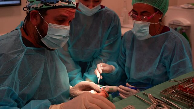 Dental procedure with dentists performing tooth extraction surgery and blood aspiration