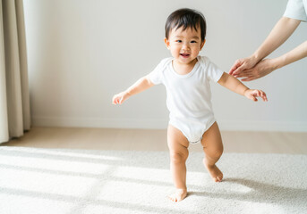 Asian infant taking first steps with supportive parent in bright room