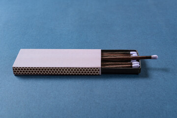 angle view lilac matchbox on a blue background at horizontal composition