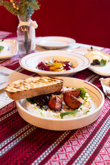 Ricotta cheese spread with sweet plums and a piece of bruchetta on a white plate